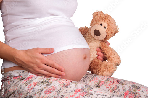 Pregnant woman with a toy bear in hands