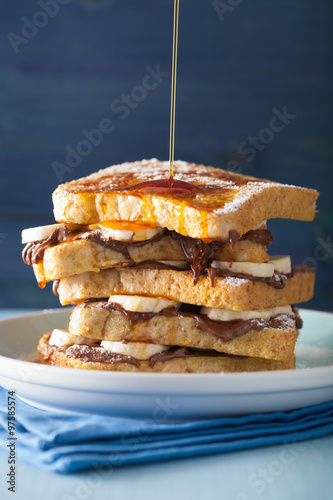 pouring caramel over french toasts with banana chocolate saucel
