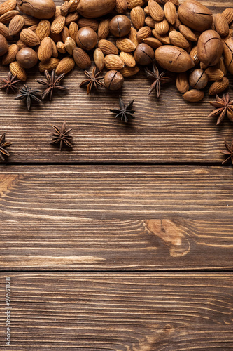 Nuts and star anise on wooden undeground. Top view.