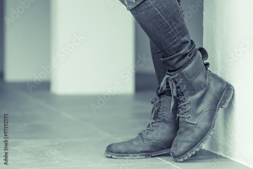 Young fashion man's legs in jeans and brown boots on the floor ,make it a green tone