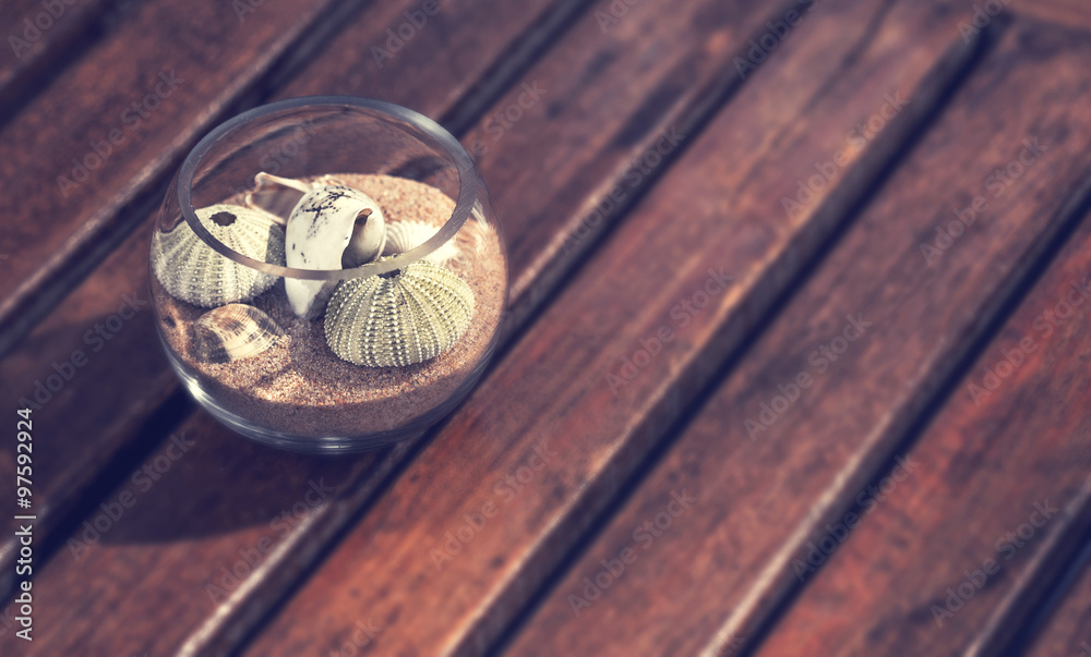 Shells in a glass jar on a wooden beach with vintage color effect Shells in a glass jar on a wooden beach with vintage color effect