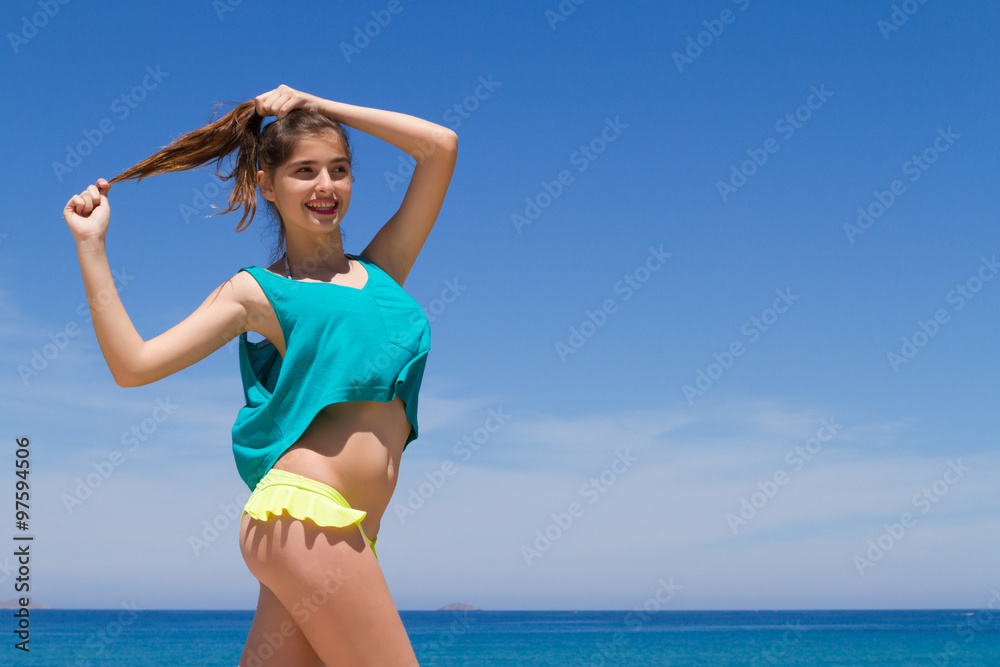 Brunette cheerful teenage in beachwear enjoys the summer. Brunette cheerful teenage in beachwear enjoys the summer.