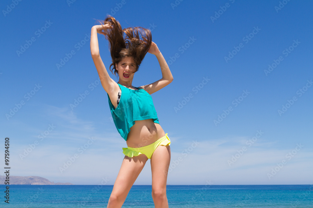 Brunette cheerful teenage in beachwear enjoys the summer. Brunette cheerful teenage in beachwear enjoys the summer.