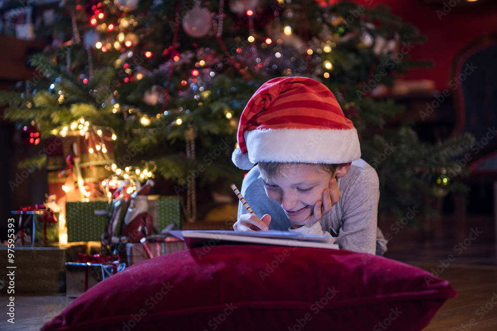 Christmas time, a little boy writing his wish list to santa Christmas time, a little boy writing his wish list to santa