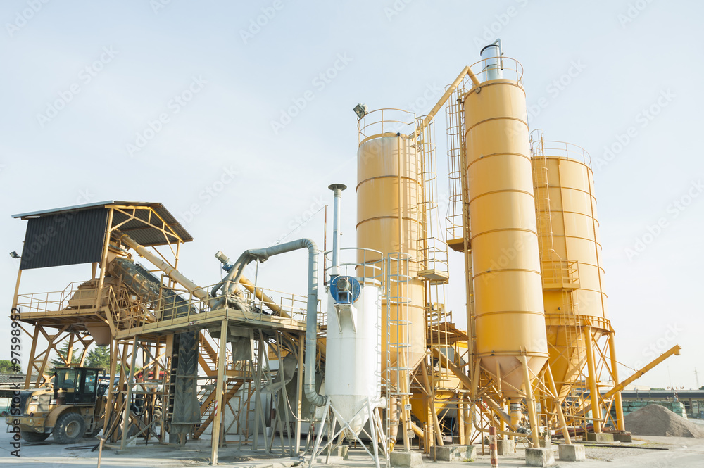 Plant for production of concrete with silos and excavator.