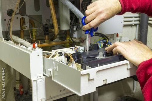 Elettricista che ripara una caldaia a condensazione photo