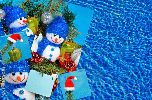 Snowman, Christmas decorations and pine branch opposite the pool