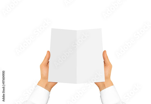 Hand in white shirt sleeve holding blank leaflet in the hand. 