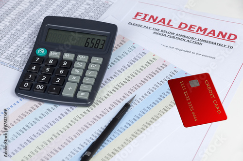 Final demand letter on a desk with a credit card and a calculator