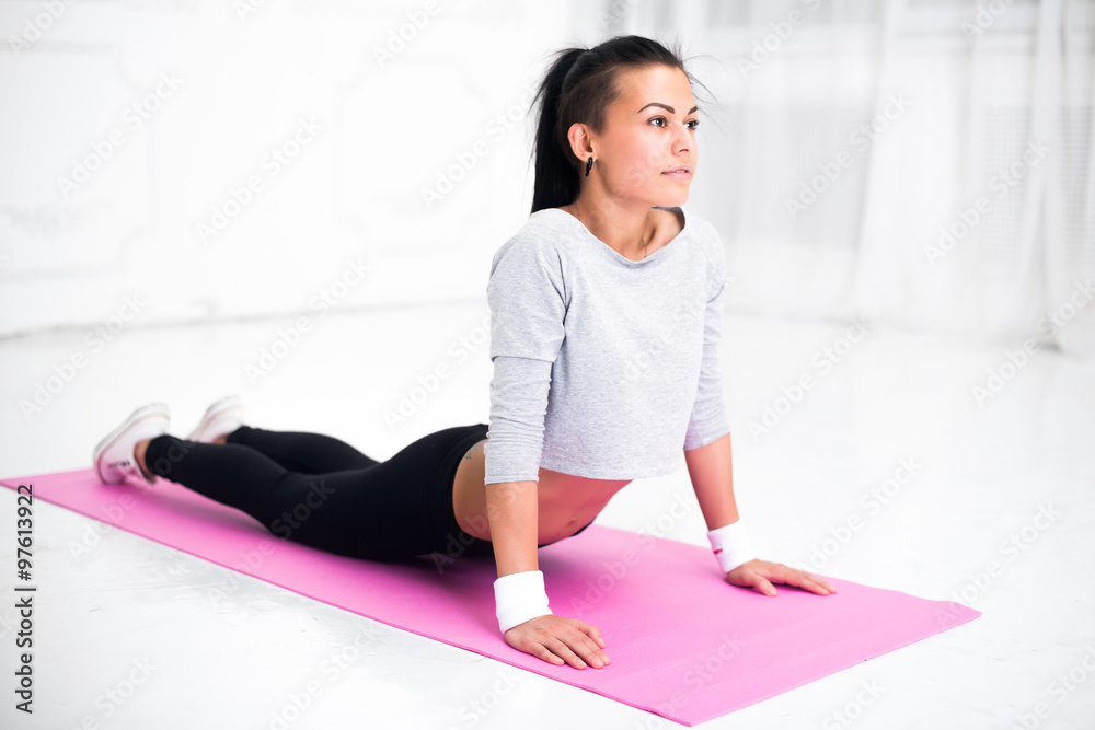 Girl doing warming up exercise for spine, backbend, arching stretching her back working out at home or yoga class Girl doing warming up exercise for spine, backbend, arching stretching her back working out at home or yoga class
