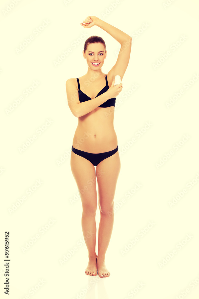 Naklejka premium Woman applying antiperspirant.