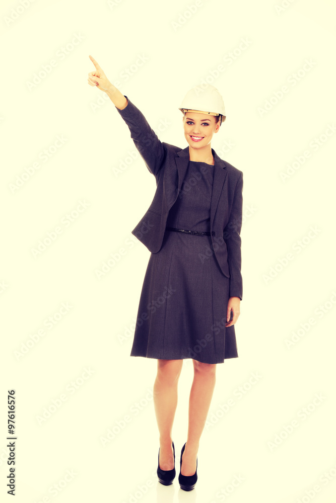Businesswoman in hard hat pointing up. Businesswoman in hard hat pointing up.