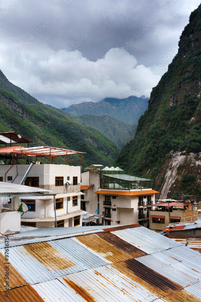 Houses at beneath of mountain range against sky, Machu Picchu, Cusco Region, Urubamba Province, Machupicchu District, Peru