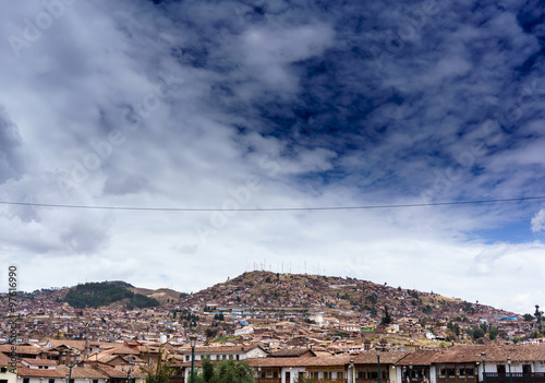 View of mountainside cityscape against cloudy sky, Cusco, Peru