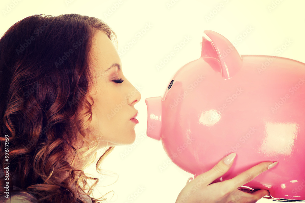 Business woman kissing a piggybank.