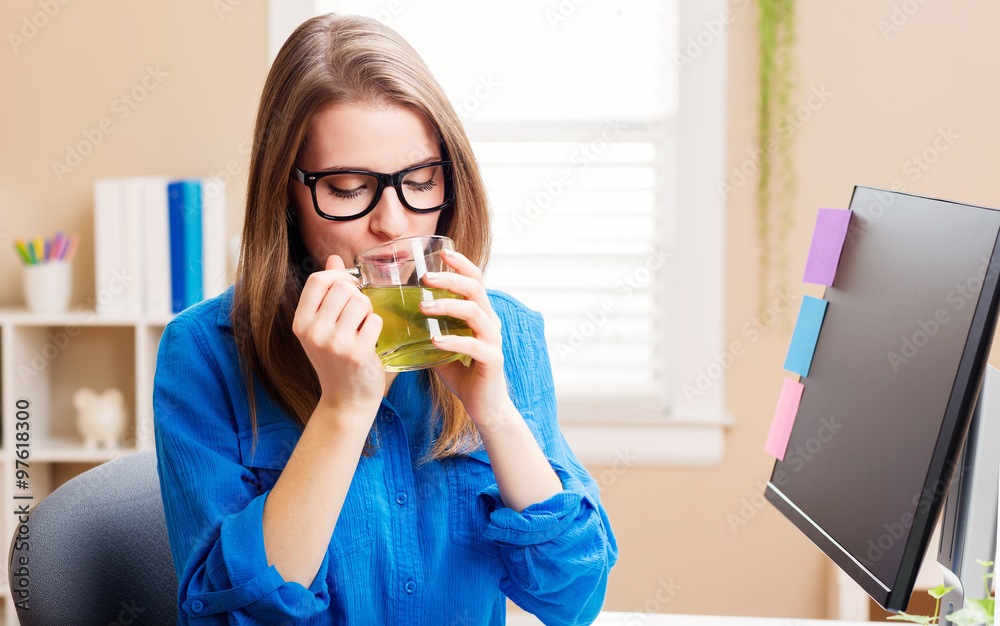 Happy young woman in her home office with tea Happy young woman in her home office with tea