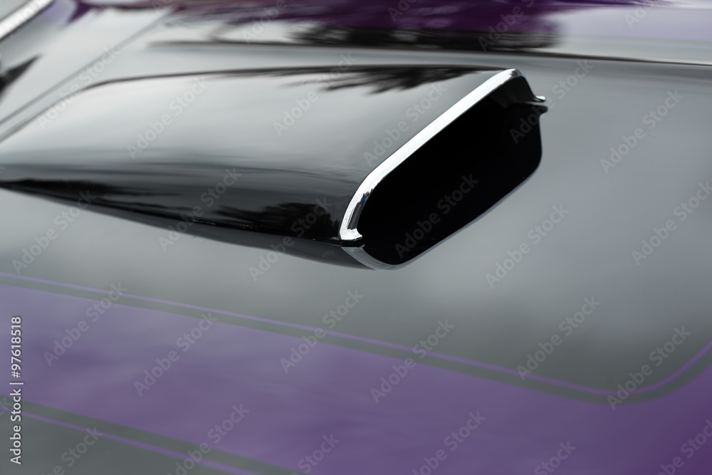 Close-up of black bonnet scoop of a black and purple shiny classic vintage car