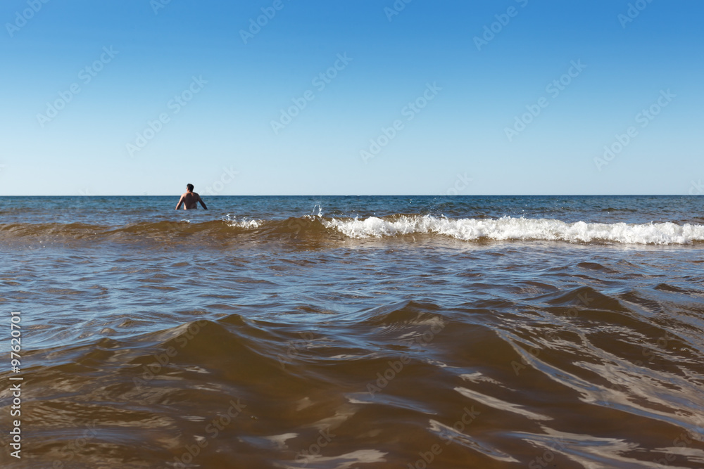 Rear view of a shirtless man in sea, Prince Edward Island, Canada