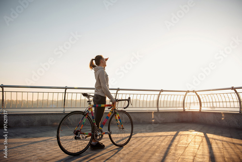 Young woman and bike in city