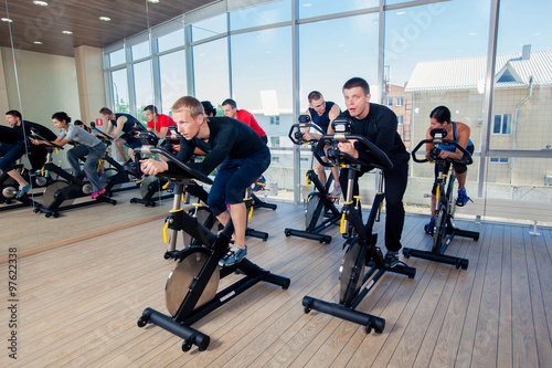 Group of gym people on machines, cycling In Class