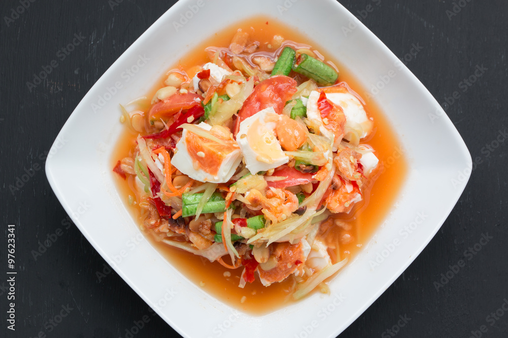 Green papaya salad with salted egg on wood table Green papaya salad with salted egg on wood table