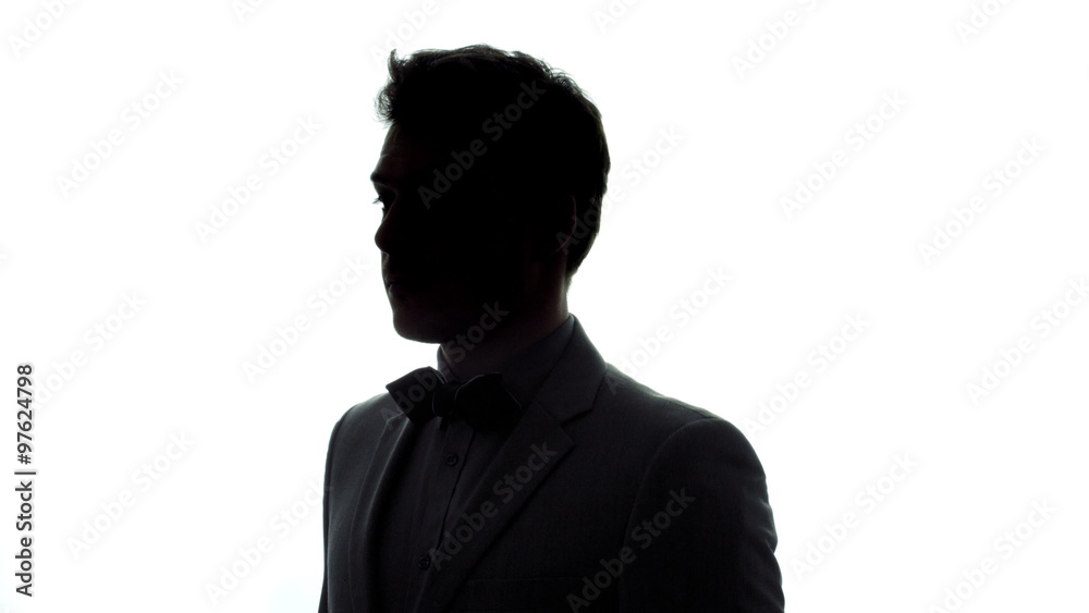 Rotating Portrait of a Well-Dressed Young Man with a Classic Black and White Bow Tie In Silhouette Isolated on White Background Rotating Portrait of a Well-Dressed Young Man with a Classic Black and White Bow Tie In Silhouette Isolated on White Background