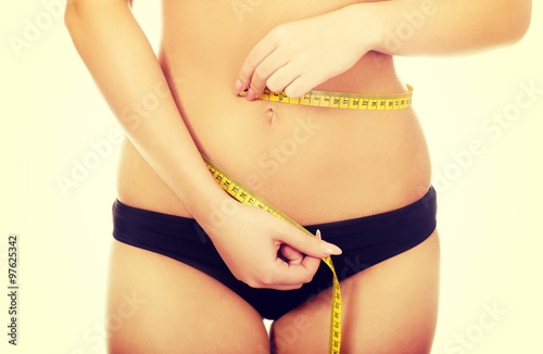 Woman measuring her waist.