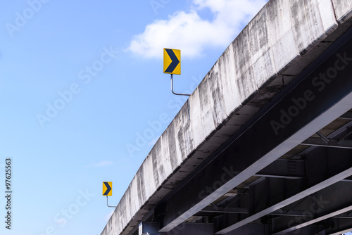 Bridge and right arrow sign with blue sky.