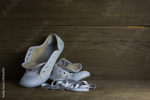 White canvas shoes on wood background, still life