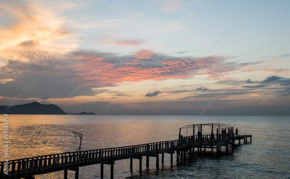 Silhouette Bridge and pavillion on the sea with people walk on t