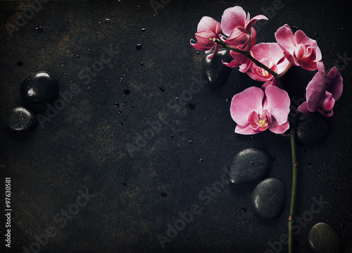 Spa stones and pink orchid on the dark background photo