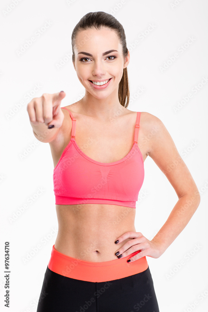 Attractive cheerful young female athlete pointing on you Attractive cheerful young female athlete pointing on you