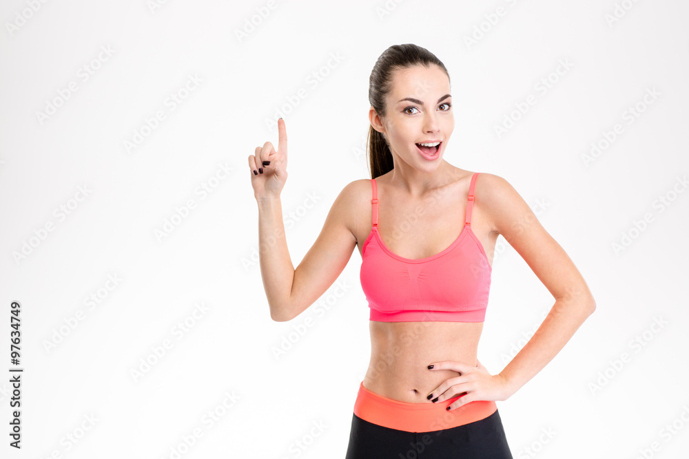 Beautiful sportswoman in tracksuit pointing up and having an idea Beautiful sportswoman in tracksuit pointing up and having an idea