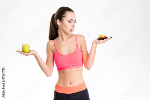 Portrait of tempted attractive fitness woman making food choice