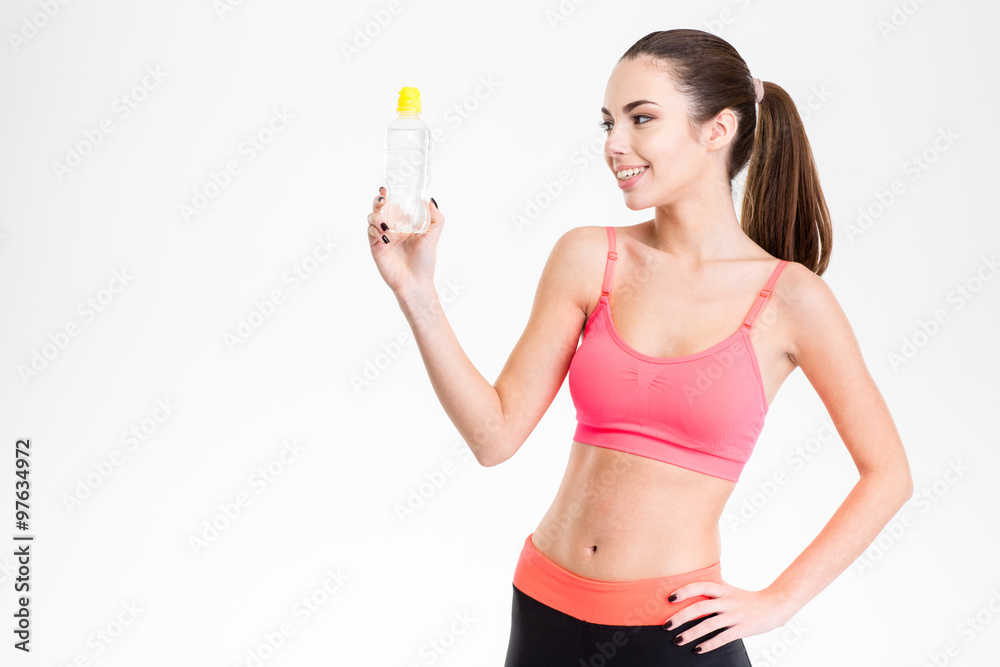 Smiling cute lovely fitness girl looking at bottle of water Smiling cute lovely fitness girl looking at bottle of water