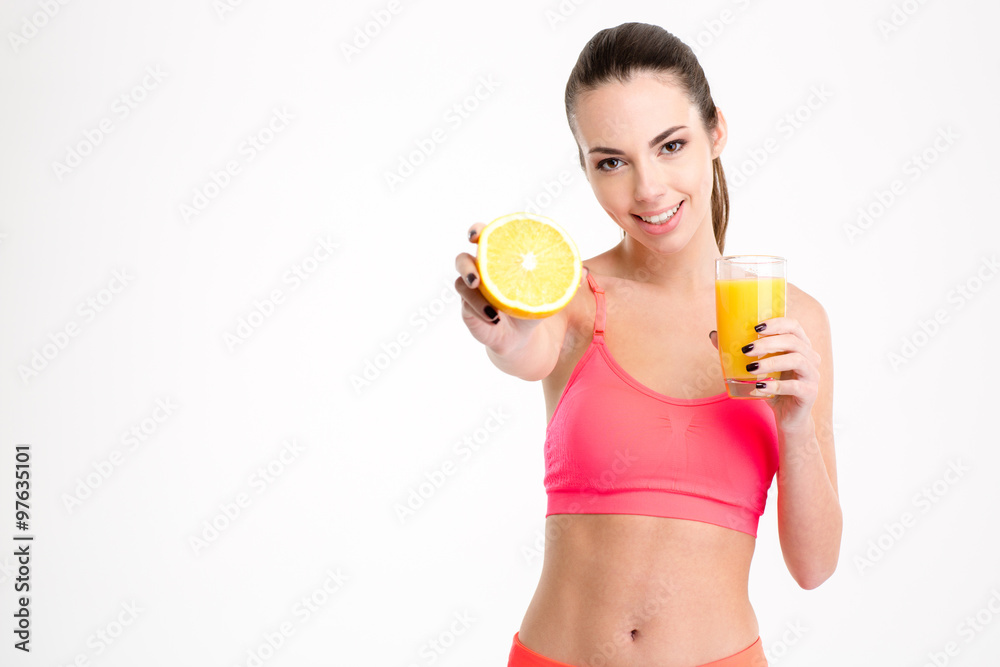 Positive attrative young sportswoman showing an orange half Positive attrative young sportswoman showing an orange half