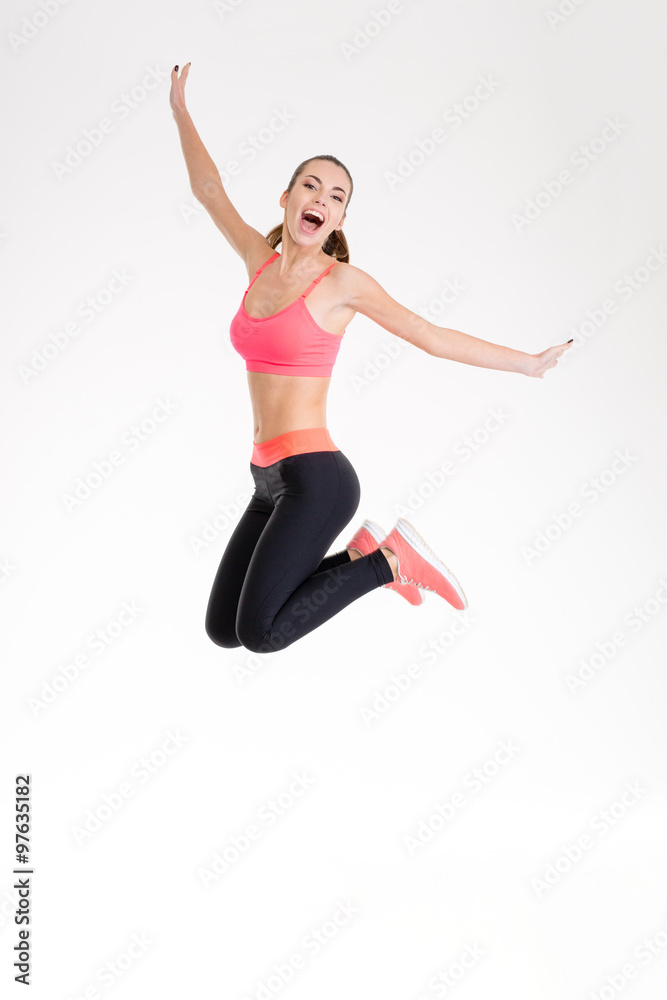 Happy joyful young fitness woman jumping