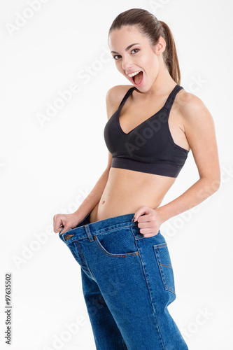 Amazed happy fitness woman became skinny and wearing old jeans © Drobot Dean