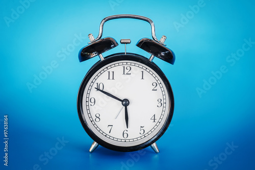 Retro alarm clock on blue background