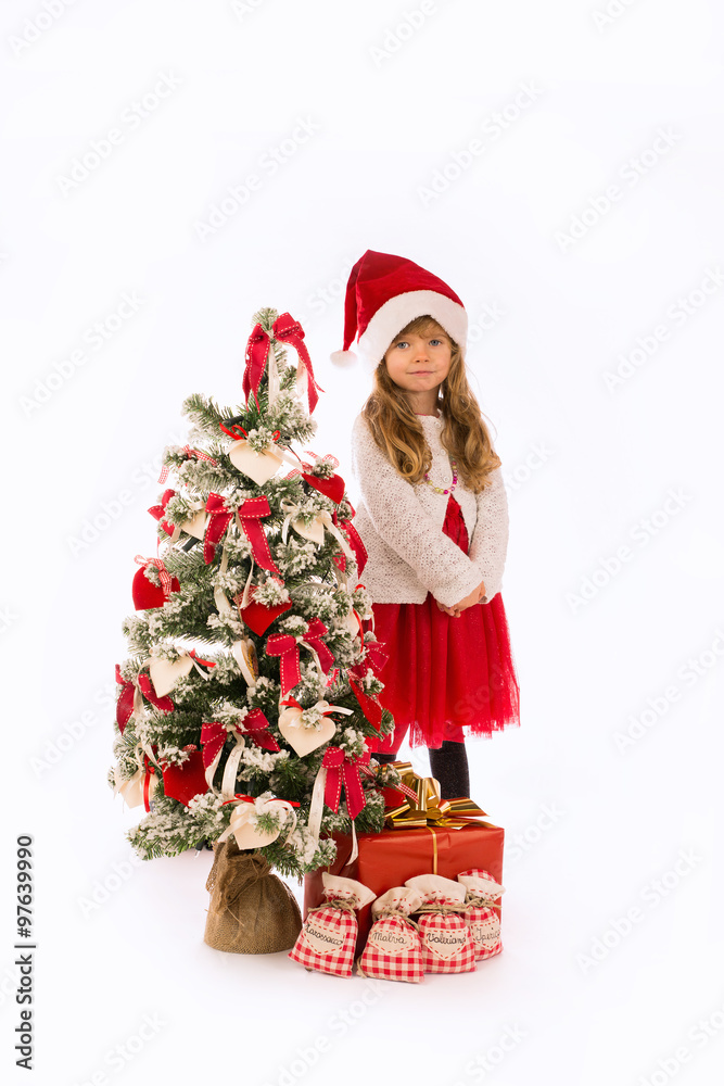 Bambina con albero di Natale, regali e cappello di Natale