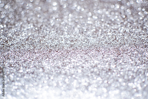 Blurry abstract bokeh lights on grey background with sparkle.