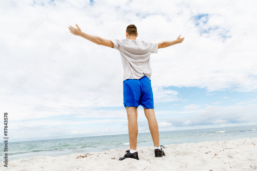 Young man in sport wear with outstretched arms Young man in sport wear with outstretched arms