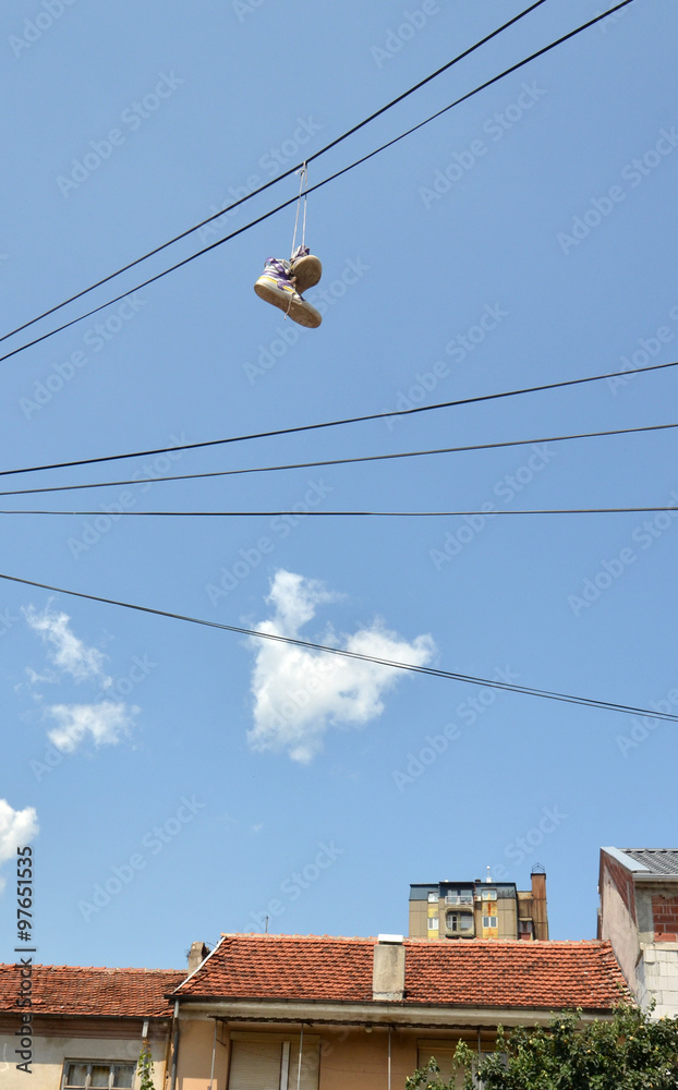 Old sneakers hanging on an electric cable Old sneakers hanging on an electric cable