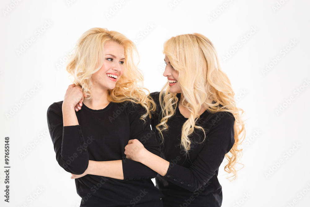 Two beautiful sisters twins looking at each other and smiling Two beautiful sisters twins looking at each other and smiling