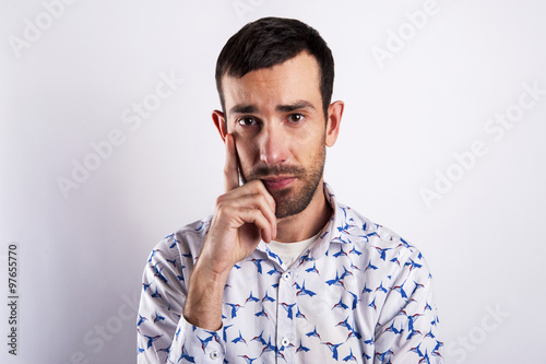 Man portriat over white background, thinking with hand near his