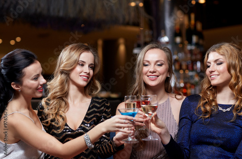 happy women with drinks at night club