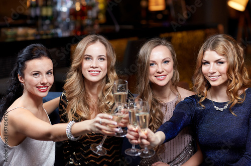 happy women with champagne glasses at night club