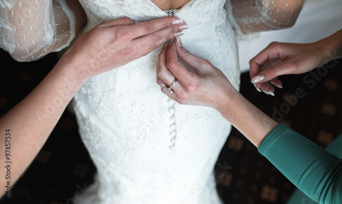 Bride putting on her dress