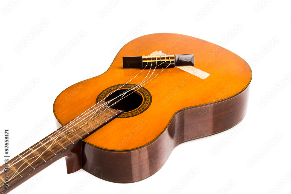 Fototapeta premium Broken brown classical guitar with detached bridge from body isolated in white background