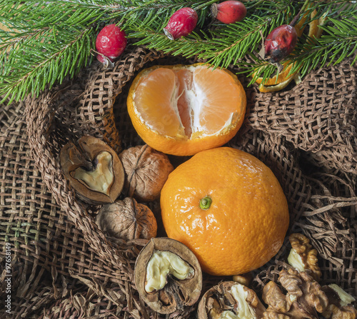 on a table covered with burlap are candles are tangerines, cones, fir or pine twig and berries. Christmas design